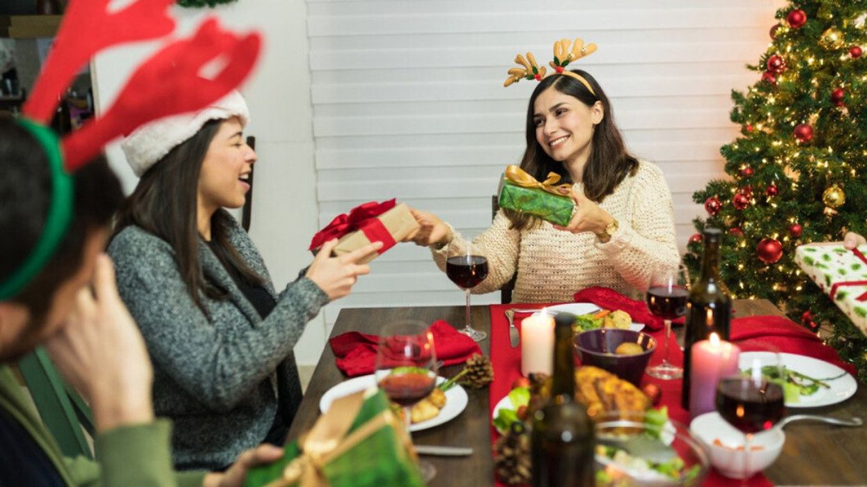A group of friends exchanging Secret Santa gifts at a Christmas dinner.