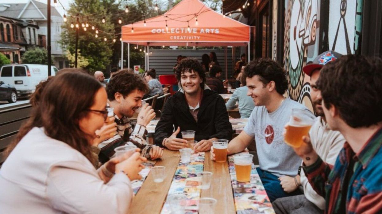 A group of friends sitting on a patio with beers.