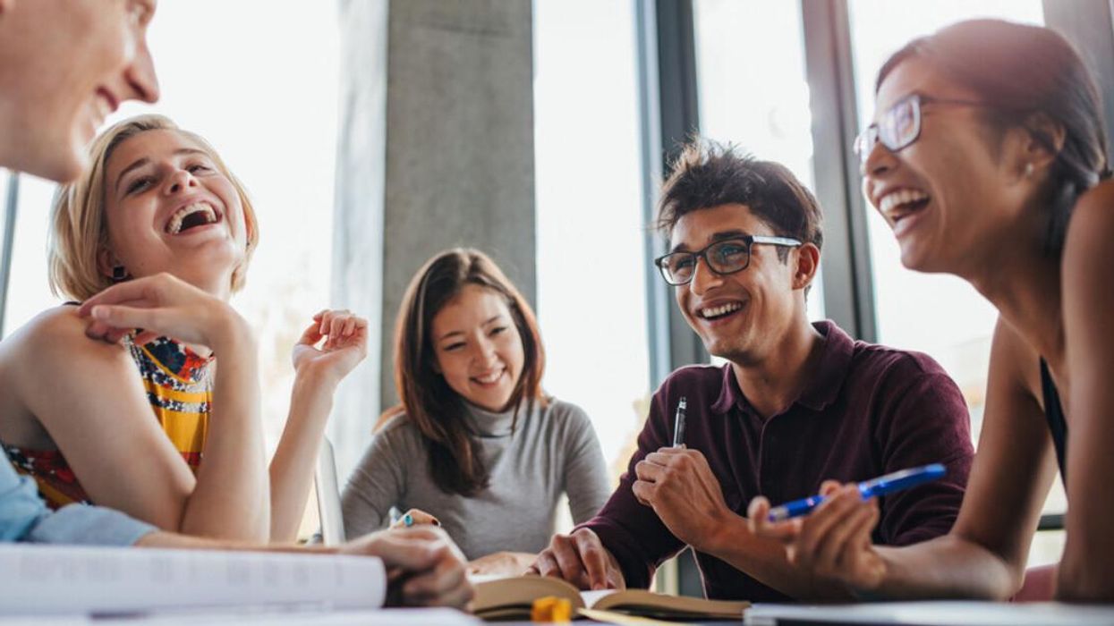A group of happy students inside a library.