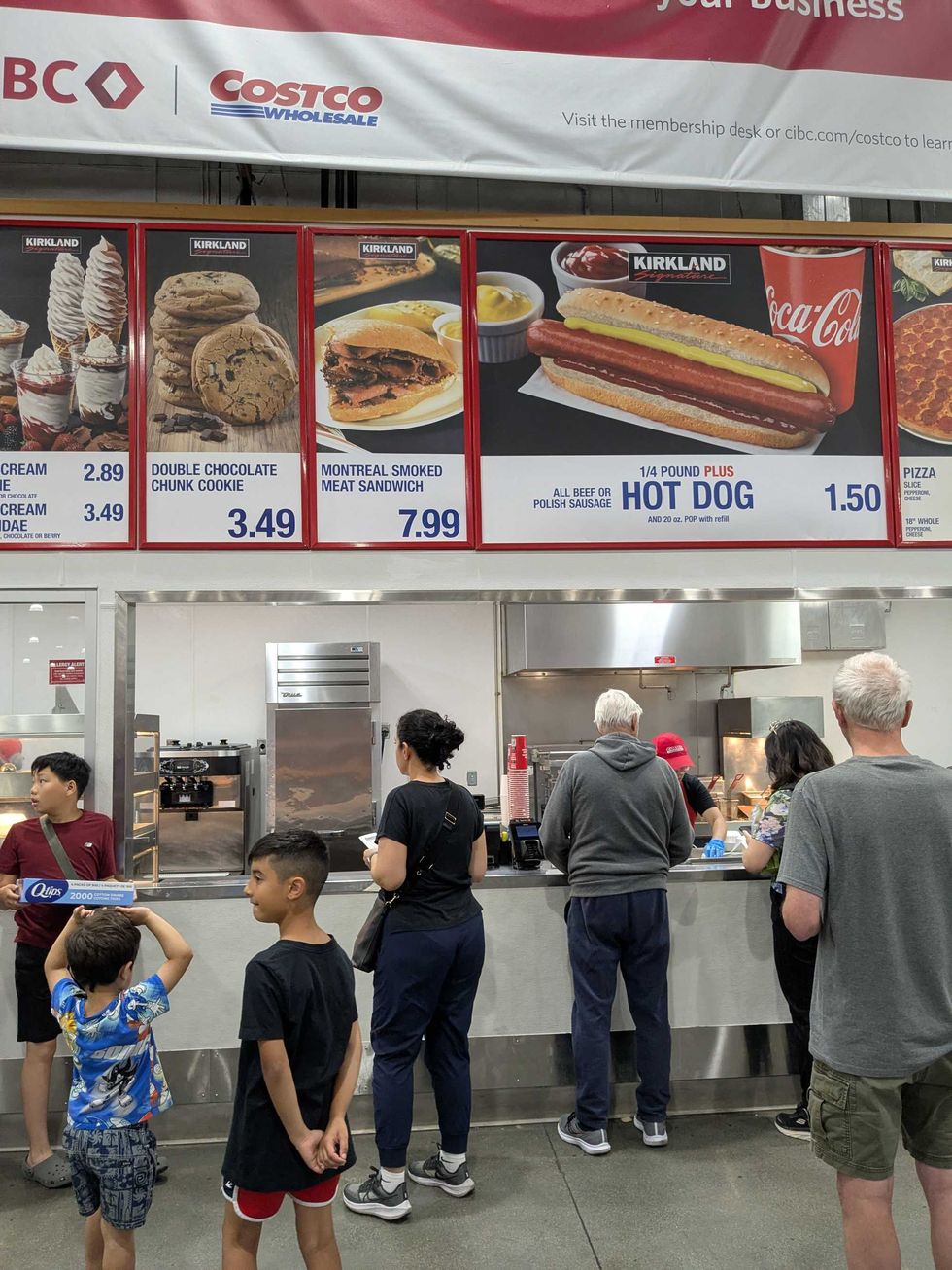 A group of people standing in front of the Costco food court