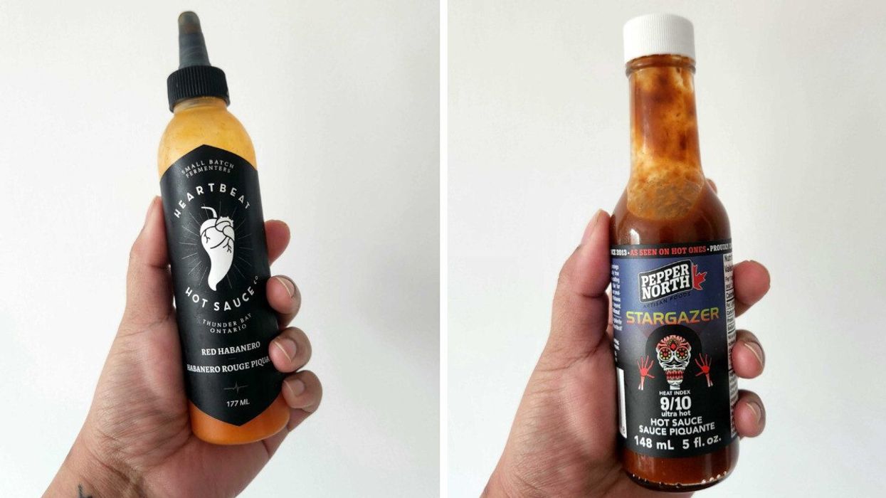 A hand holding a clear bottle of hot sauce with a black label and black lid. Right: A hand holding a clear bottle of hot sauce with a white lid and a blue and black label with a skeleton on it.