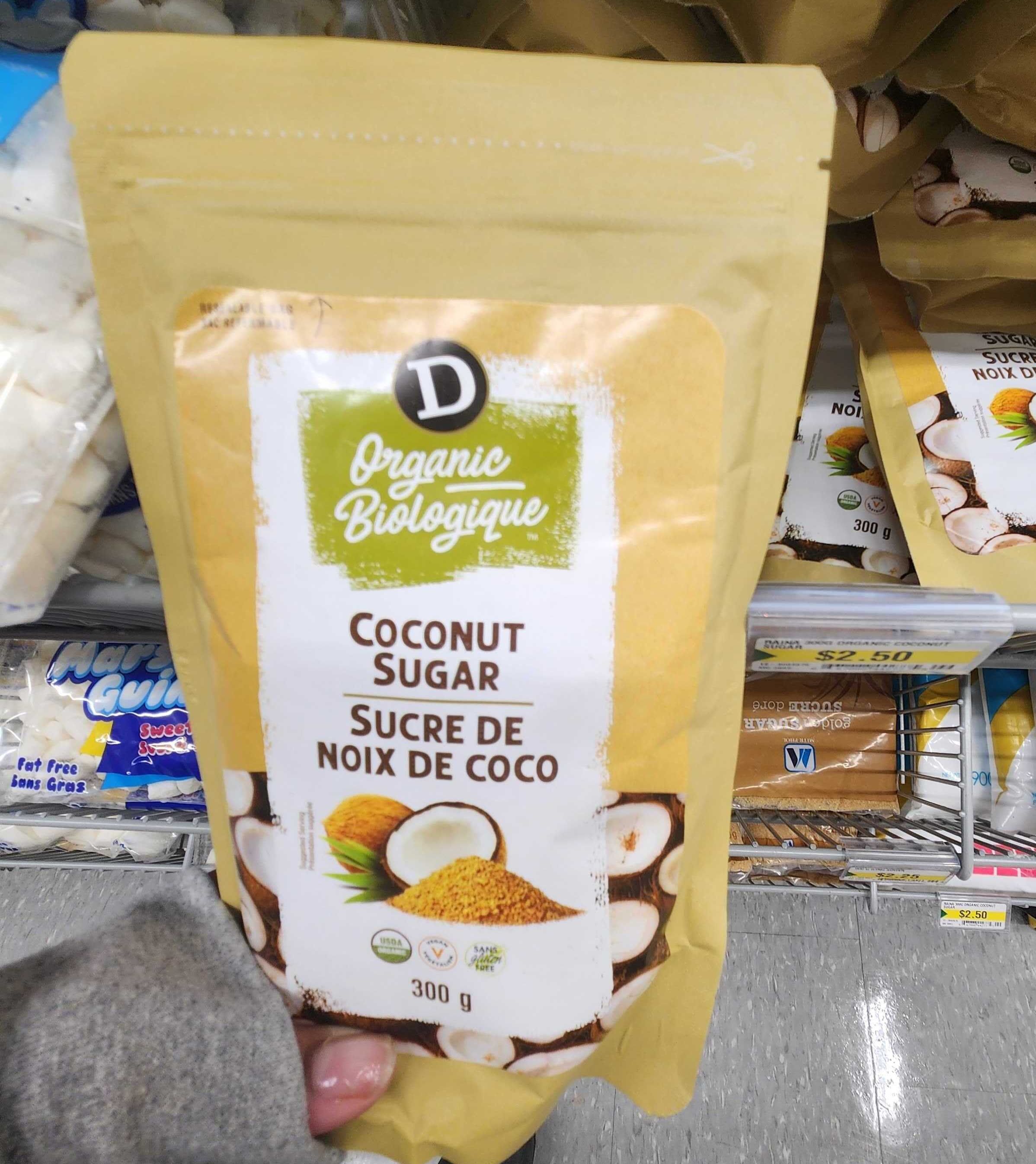 A hand holding a package of Organic Coconut Sugar.