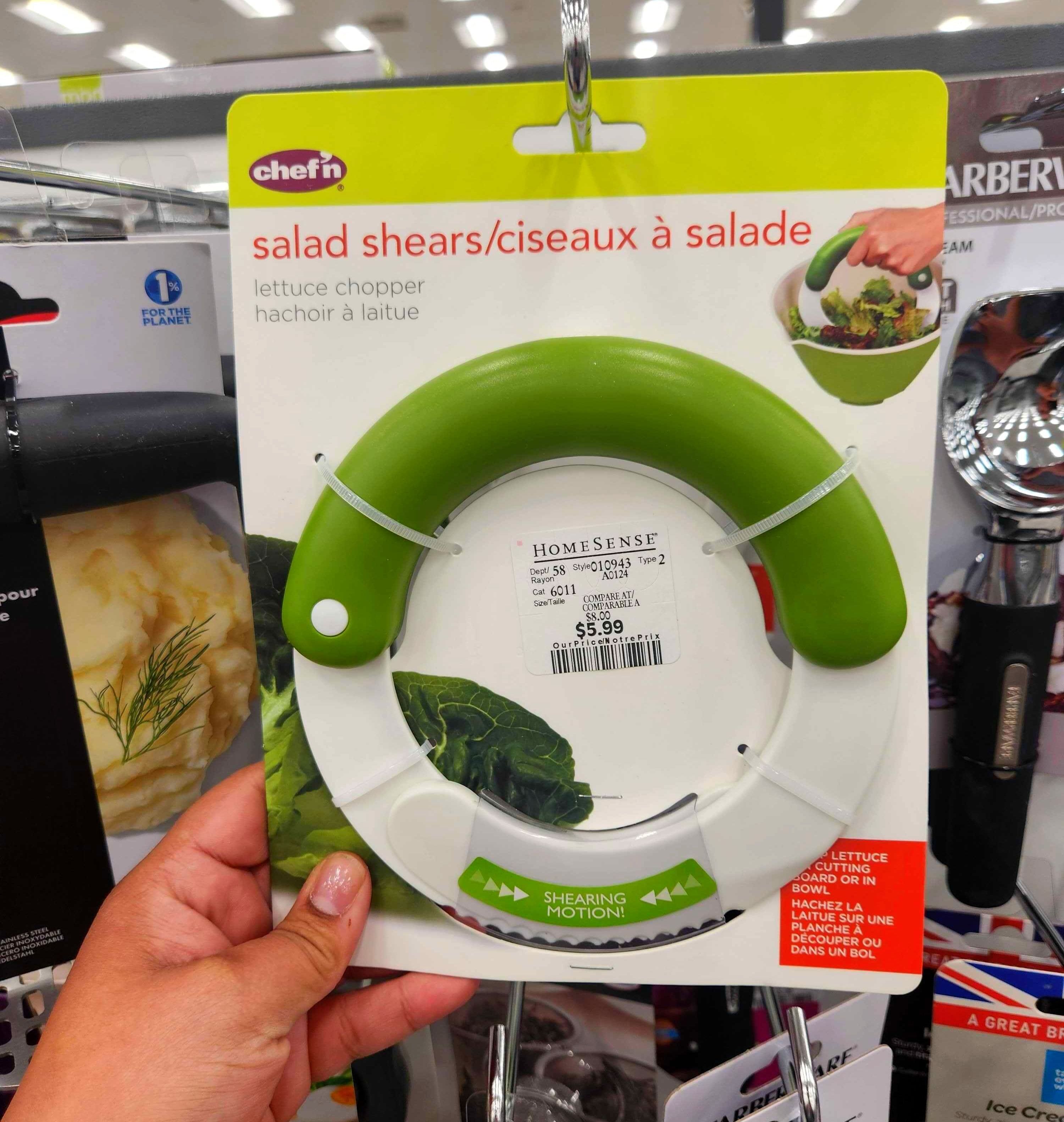 A hand holding a package with Salad Shears.