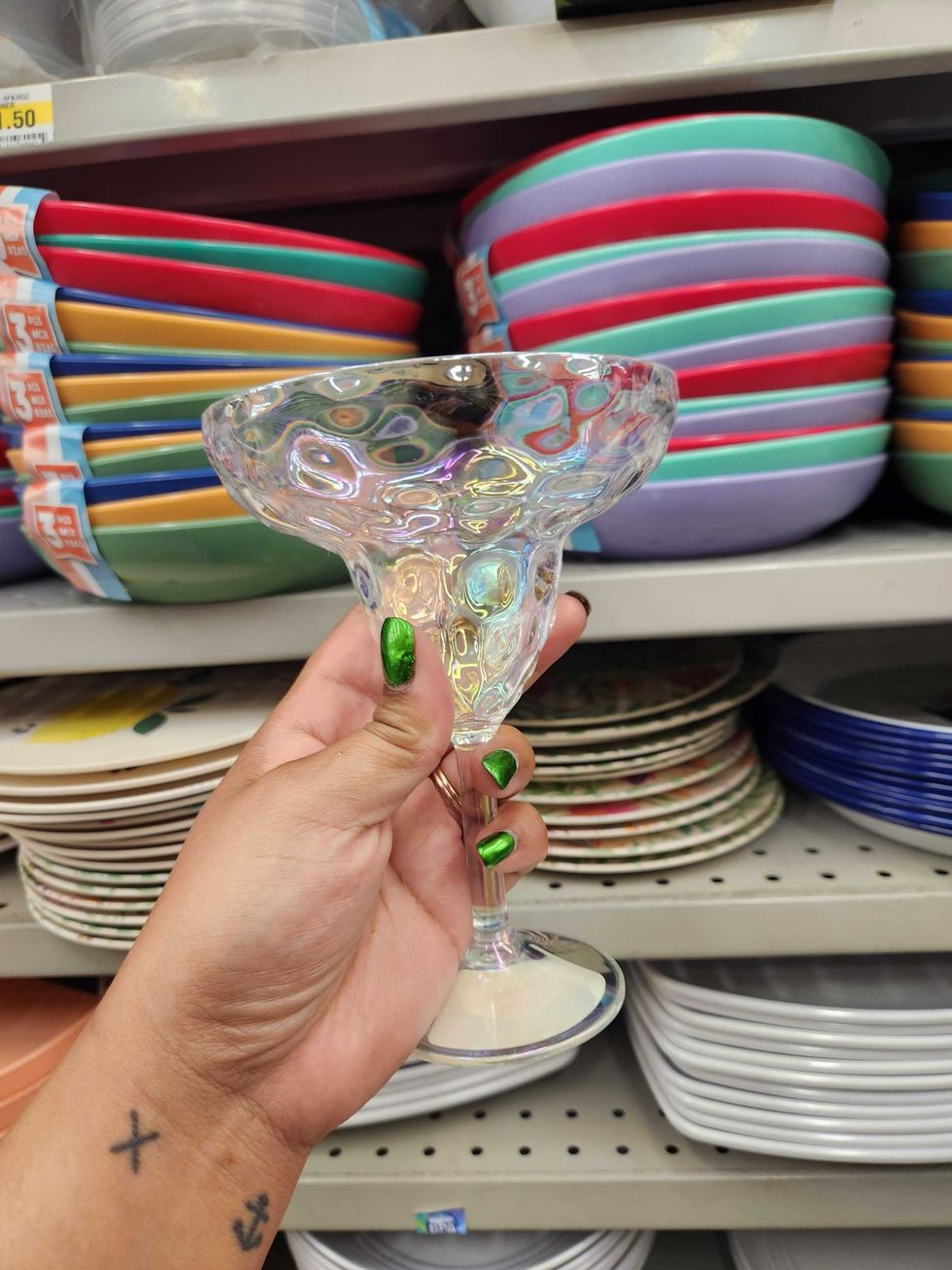 A hand holding a plastic margarita cup.