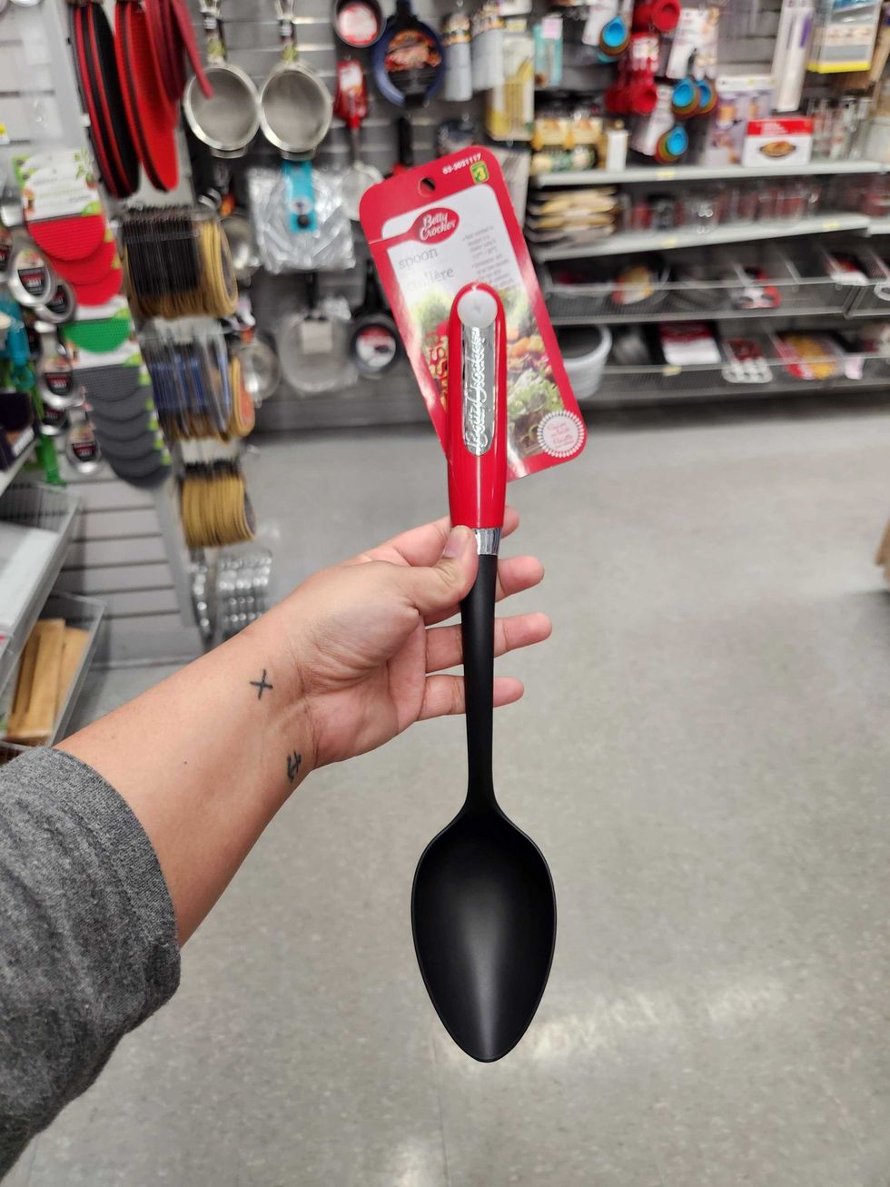 A hand holding a serving spoon.