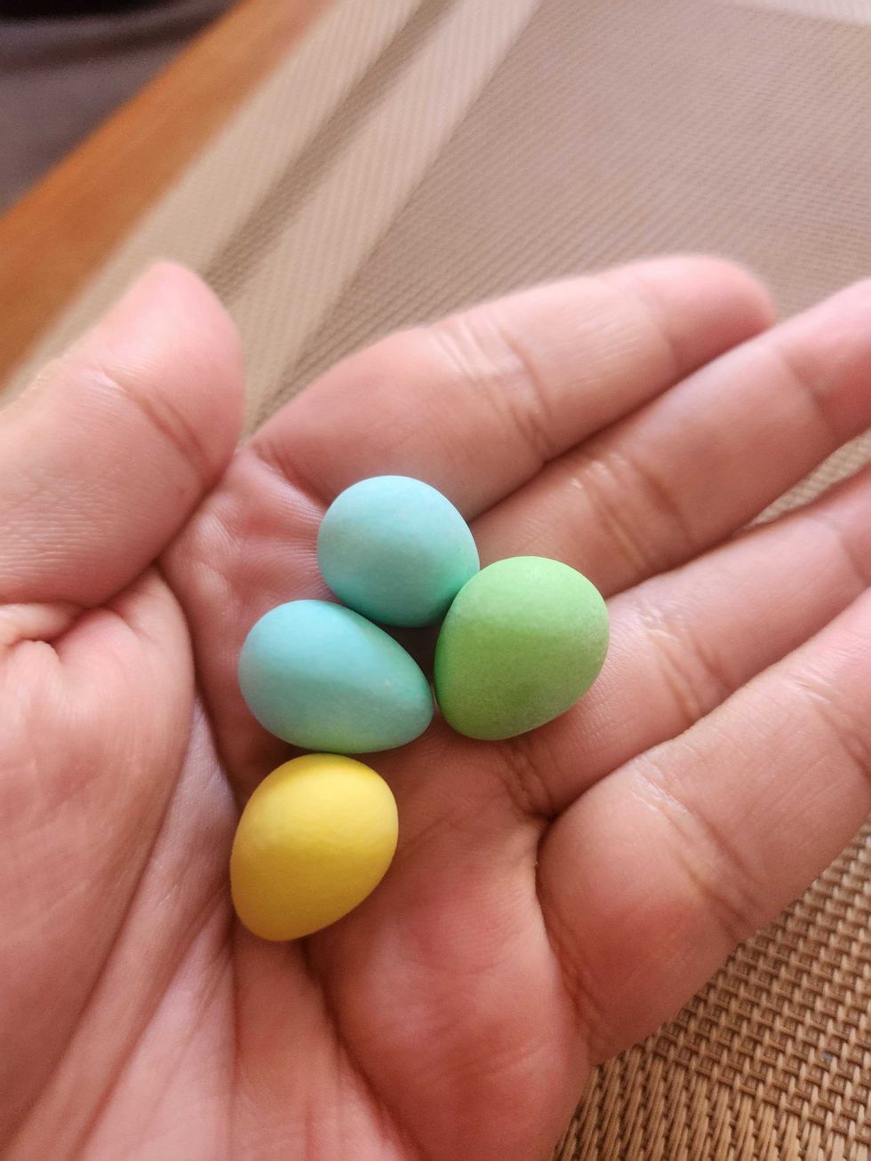 A hand holding Cadbury Mini Eggs.