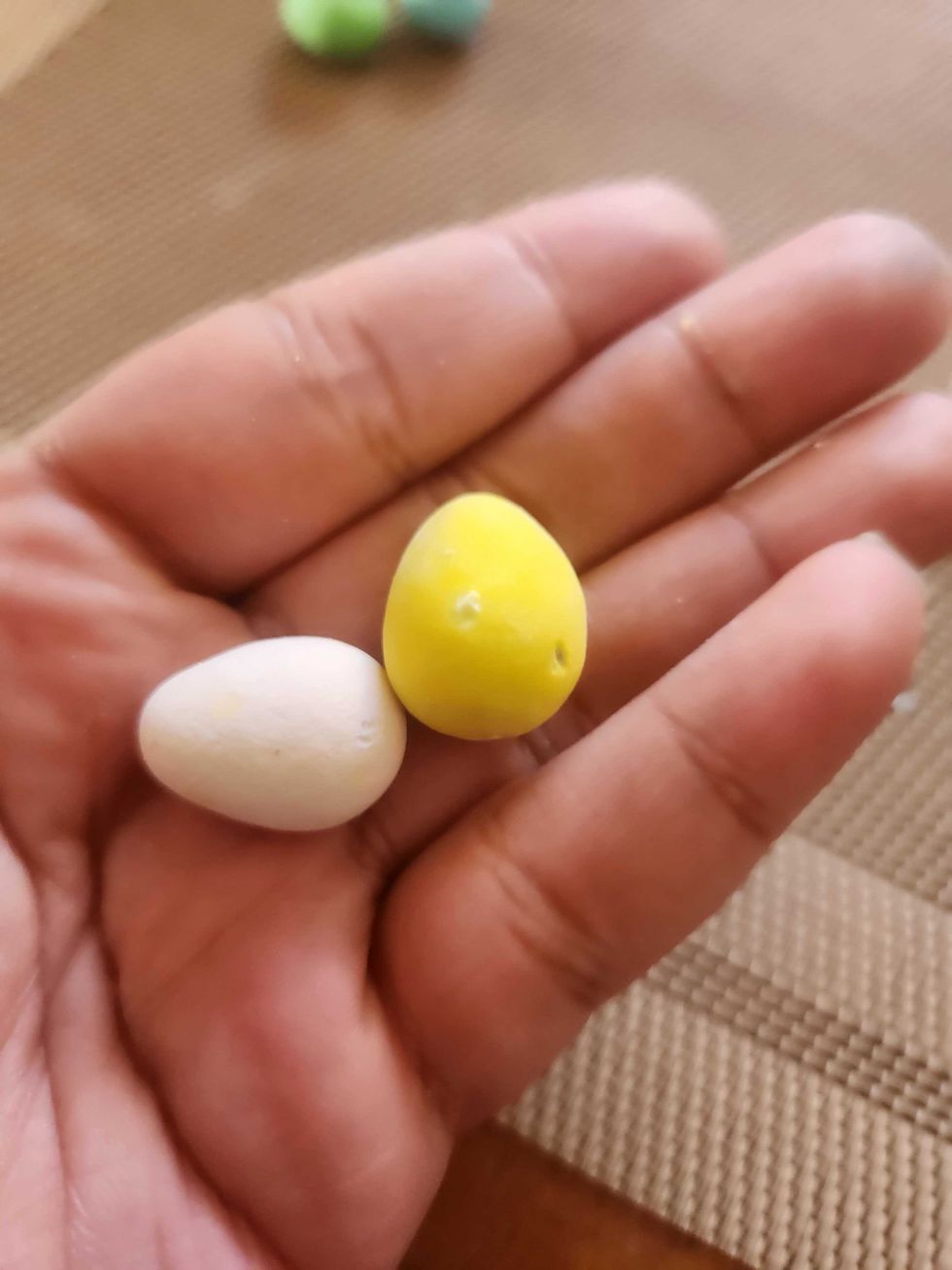 A hand holding Hershey Eggies.