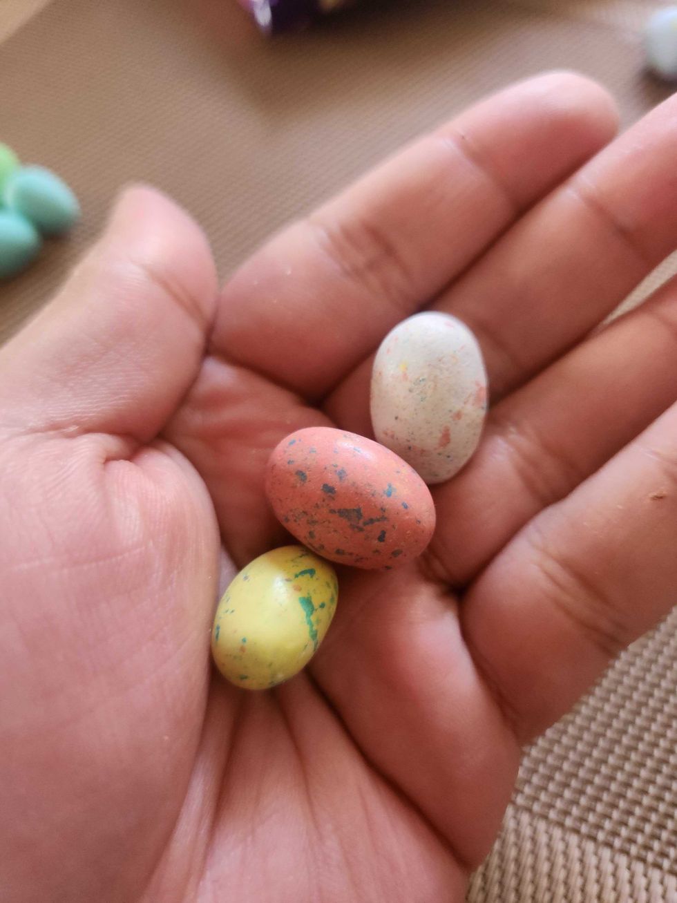A hand holding Hershey's Whoopers Eggies.