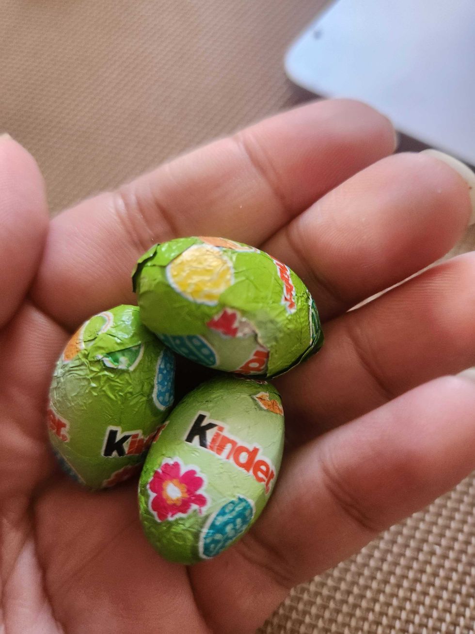 A hand holding Kinder Mini Eggs.