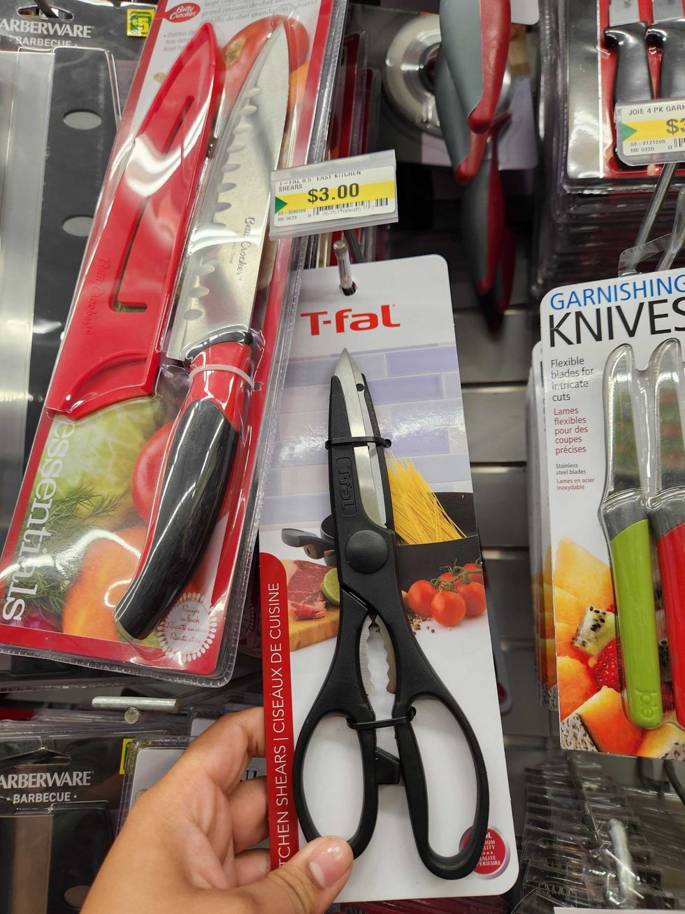 A hand holding Kitchen shears.