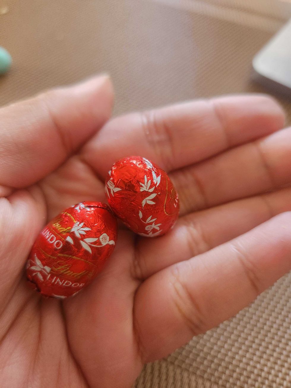 A hand holding Lindor Mini Eggs.
