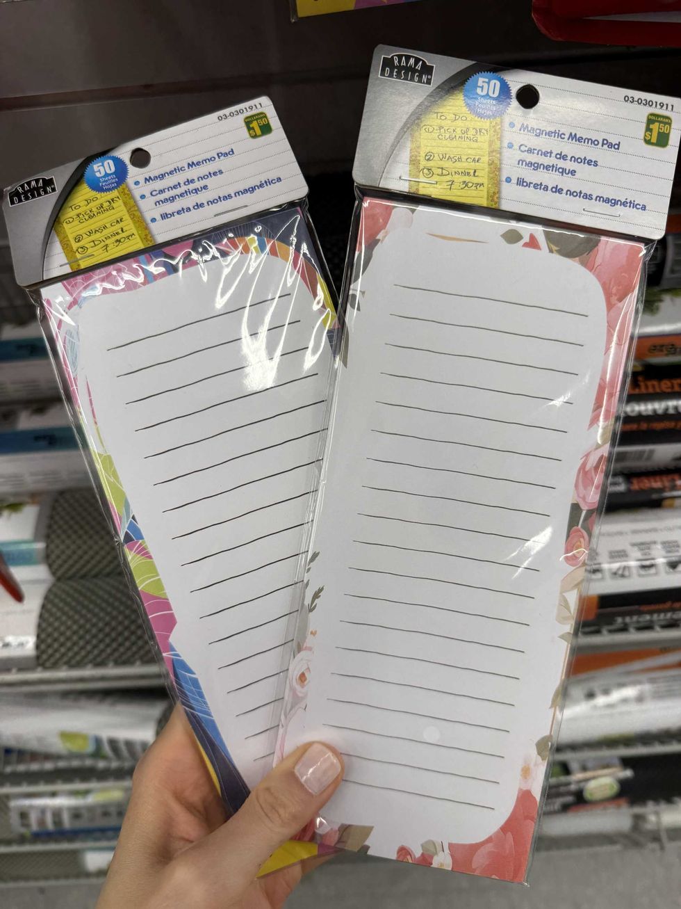 A hand holding two memo pads.