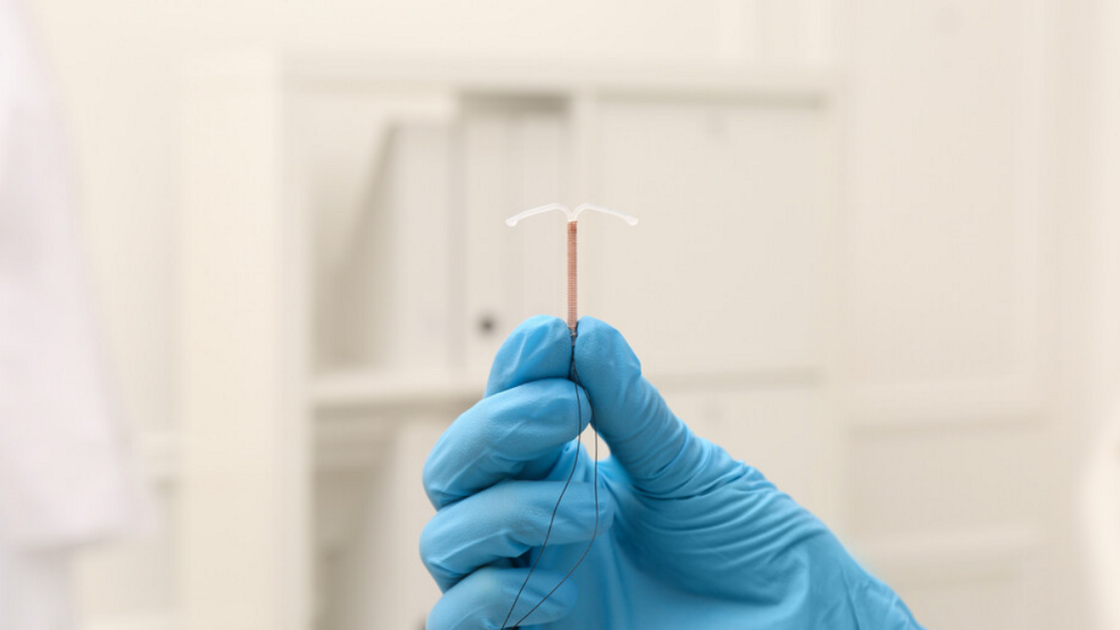 A health professional holding an IUD.