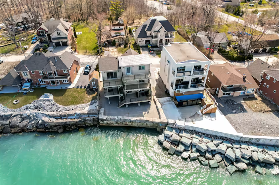 A home is seen next to turquoise blue waters.