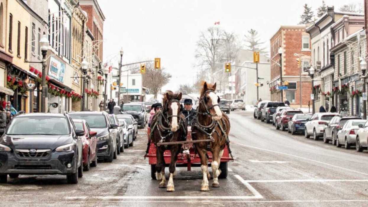 A horse-drawn wagon travelling down a street.