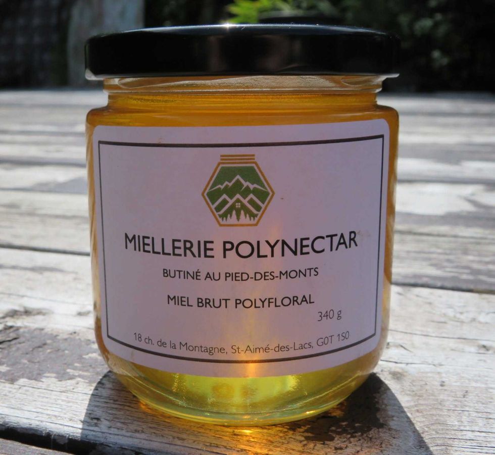 A jar of honey on a wooden table.
