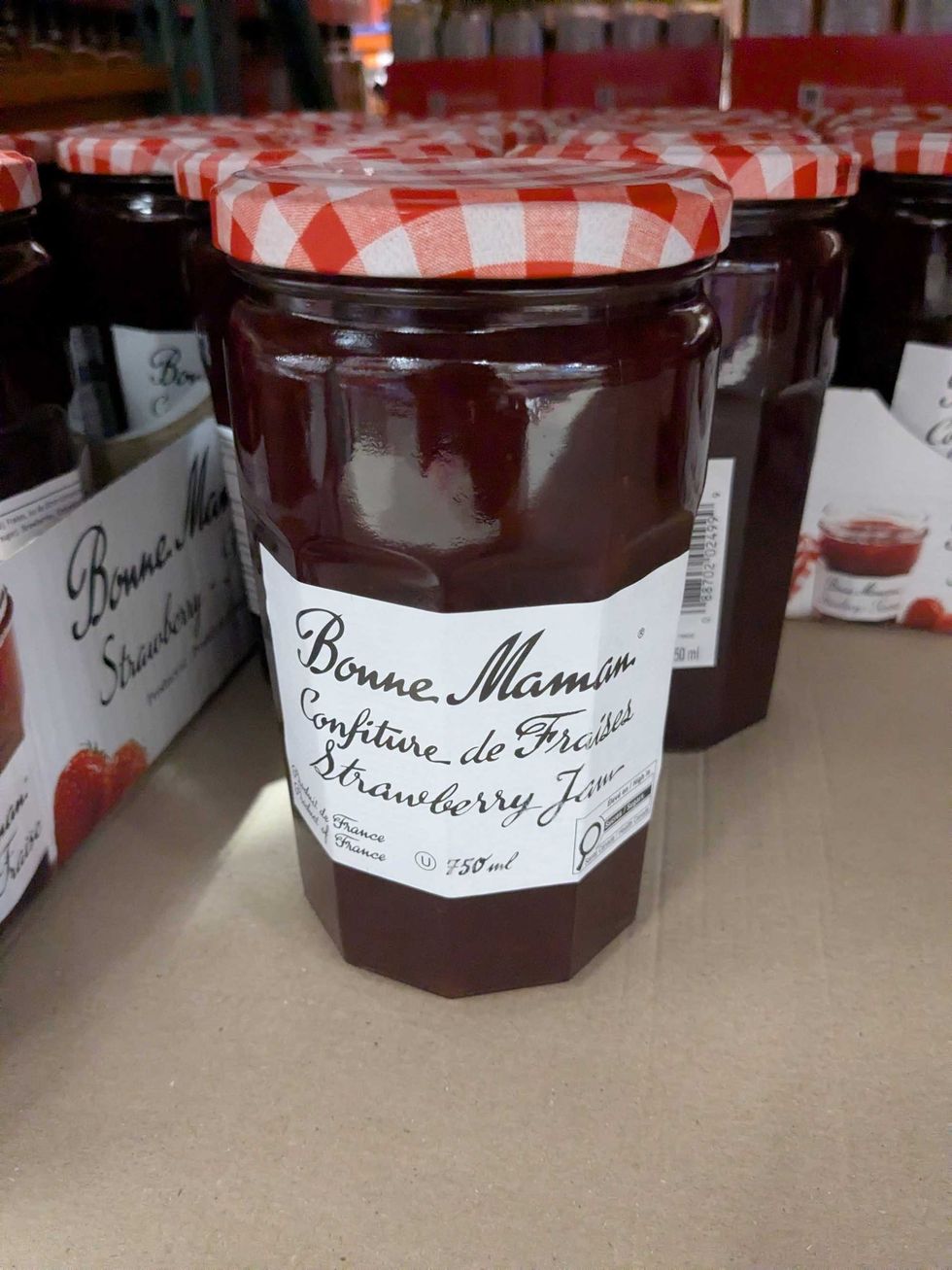 A jar of strawberry jam on a shelf