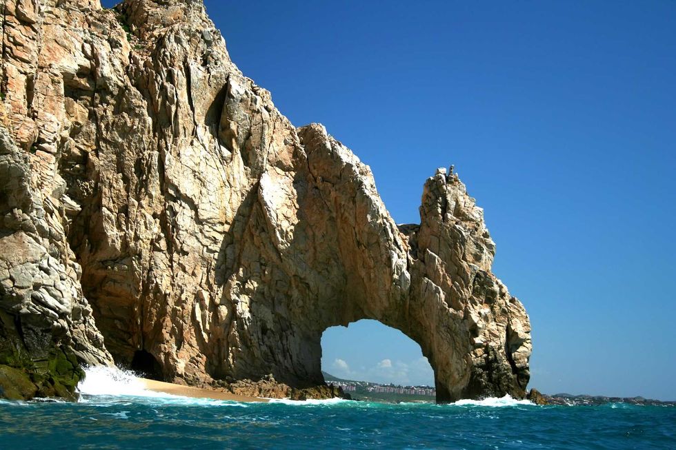 A large granite formation featuring an arch over the sea.