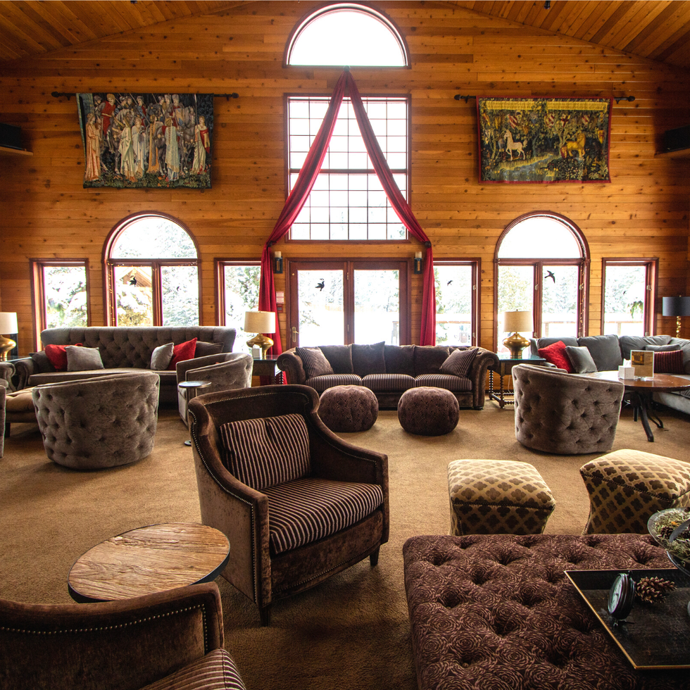 A large light filled lounge with wooden walls and luxurious furnishings at Grail Springs.