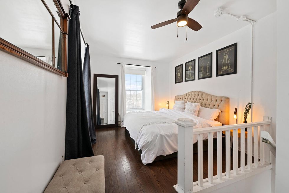A loft bedroom with a white bed.