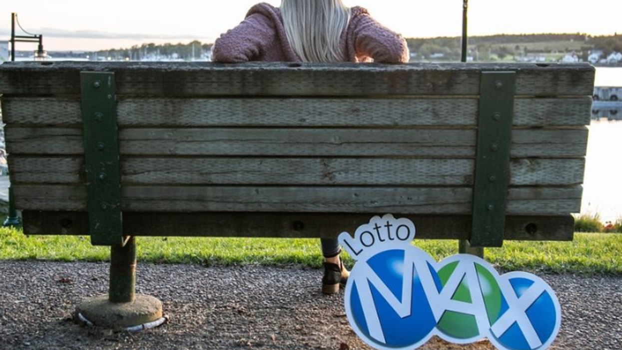 A Lotto Max sign beside a bench.