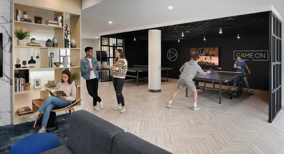 A lounge space with pool tables, couches and TVs.
