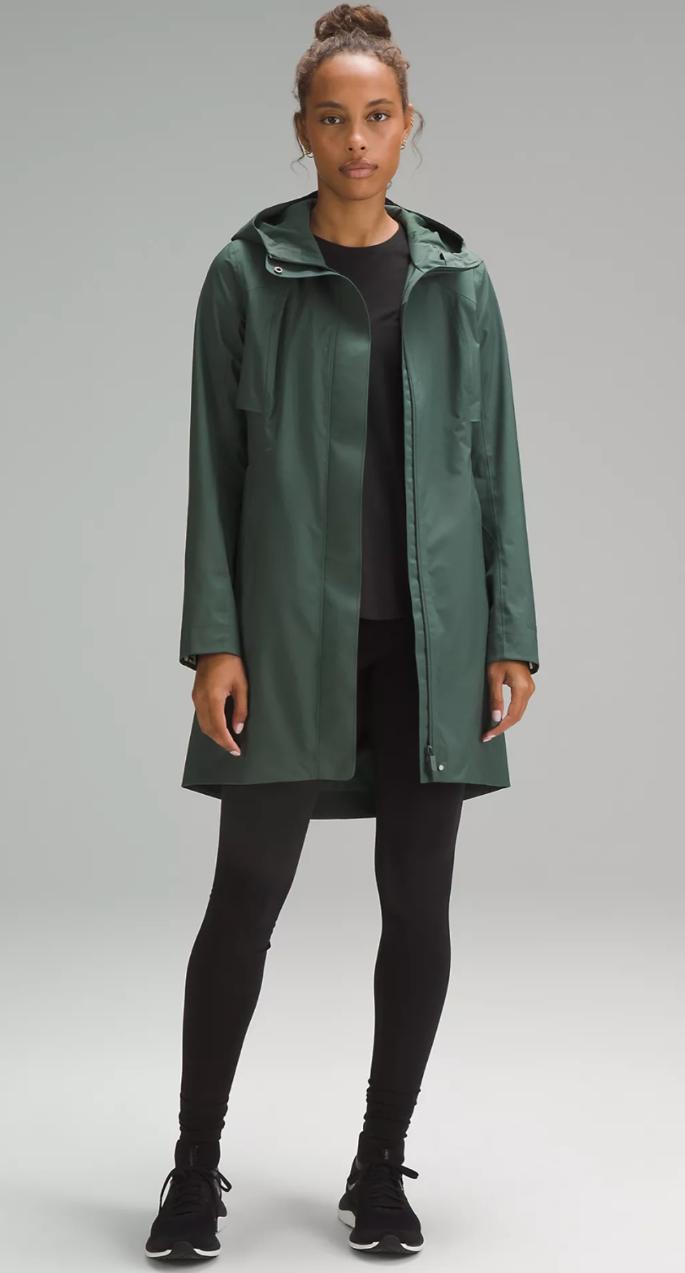A Lululemon model wearing the Rain Rebel Jacket in Dark Forest.