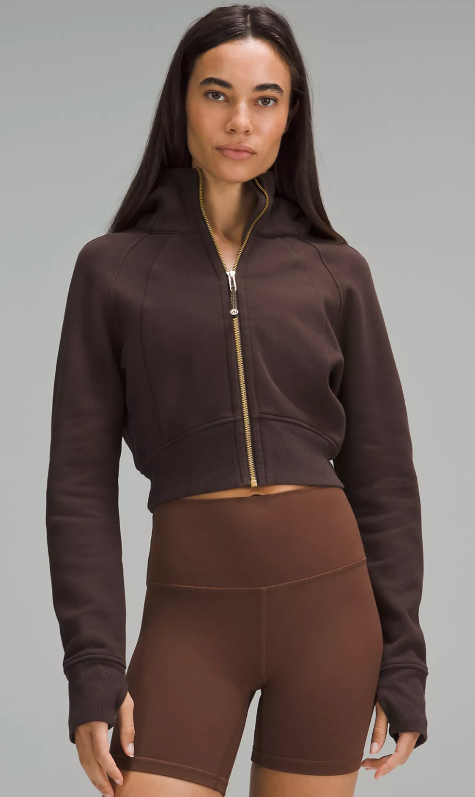 A Lululemon model wearing the Scuba Full-Zip Cropped Hoodie in Espresso.