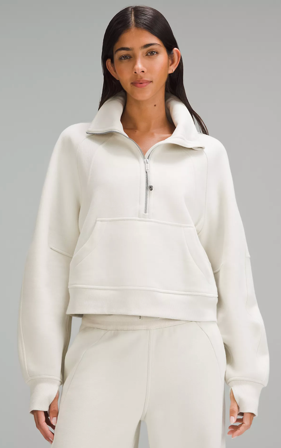 A Lululemon model wearing the Scuba Oversized Funnel-Neck Half Zip in Bone.