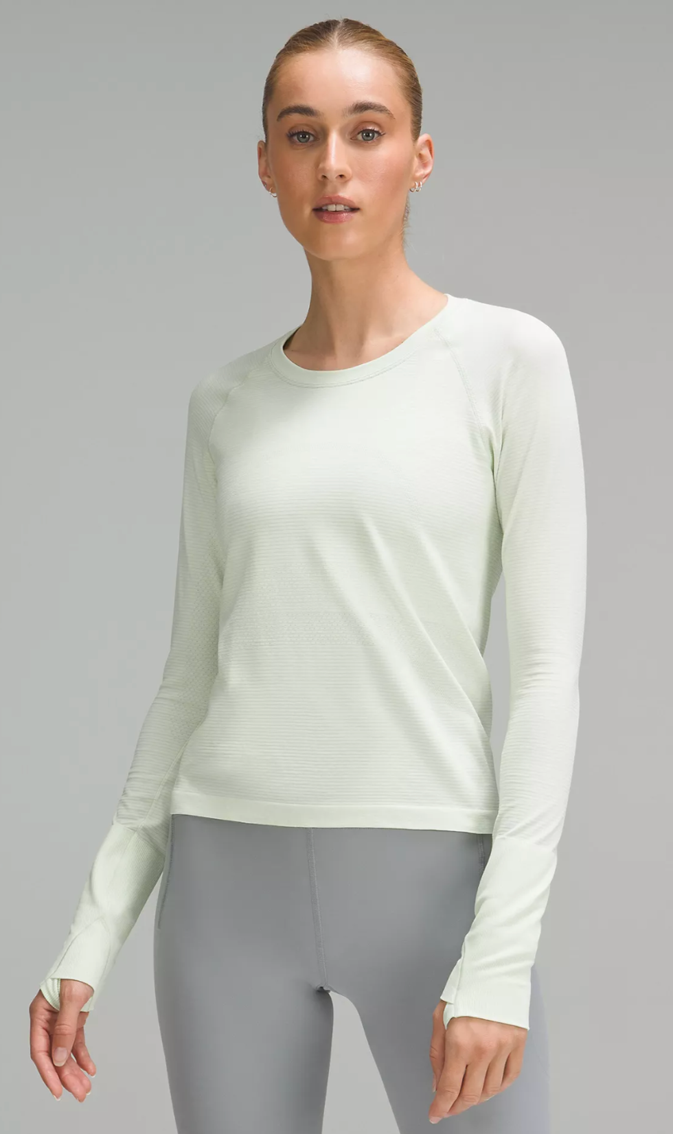 A Lululemon model wearing the Swiftly Tech Long-Sleeve Shirt 2.0 in Kohlrabi Green/White.