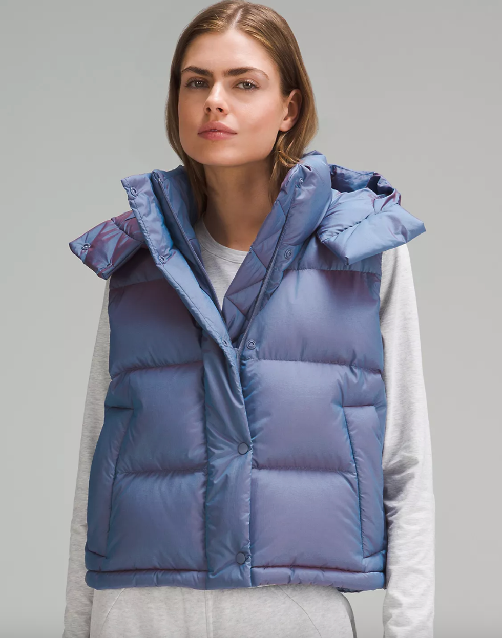 A Lululemon model wearing the Wunder Puff Cropped Vest in Heathered Wild Indigo.