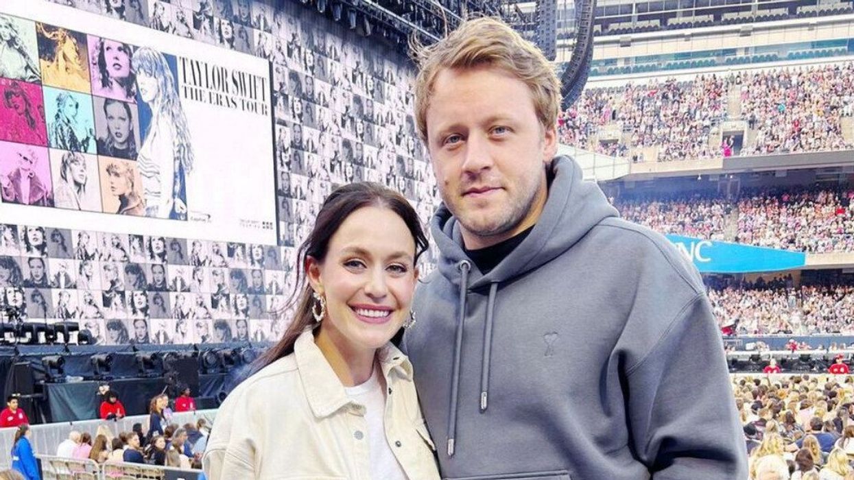 A man and woman at a Taylor Swift concert smiling for a photo.