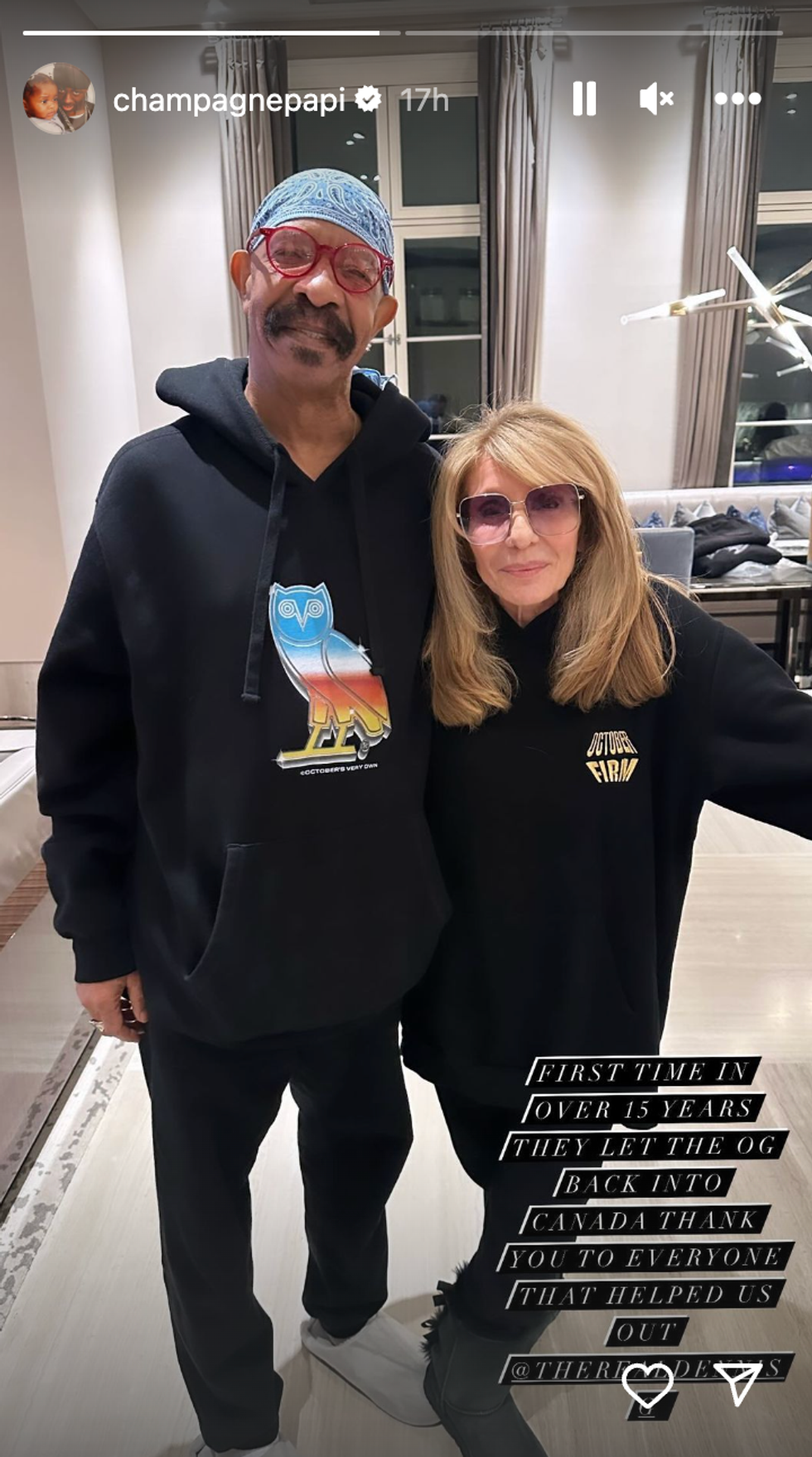 A man and woman smiling for the camera and standing in what looks like a living room.