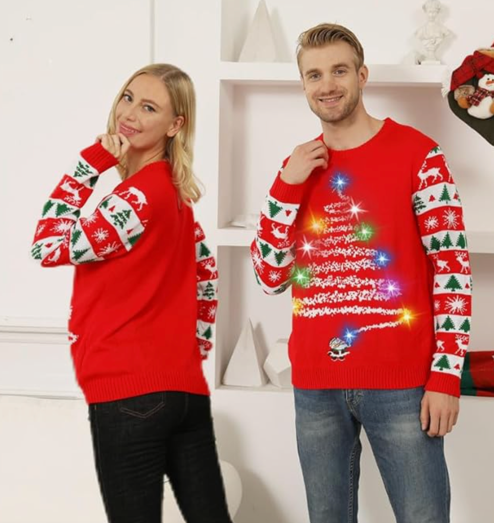 A man and woman wearing red light-up Christmas sweaters.
