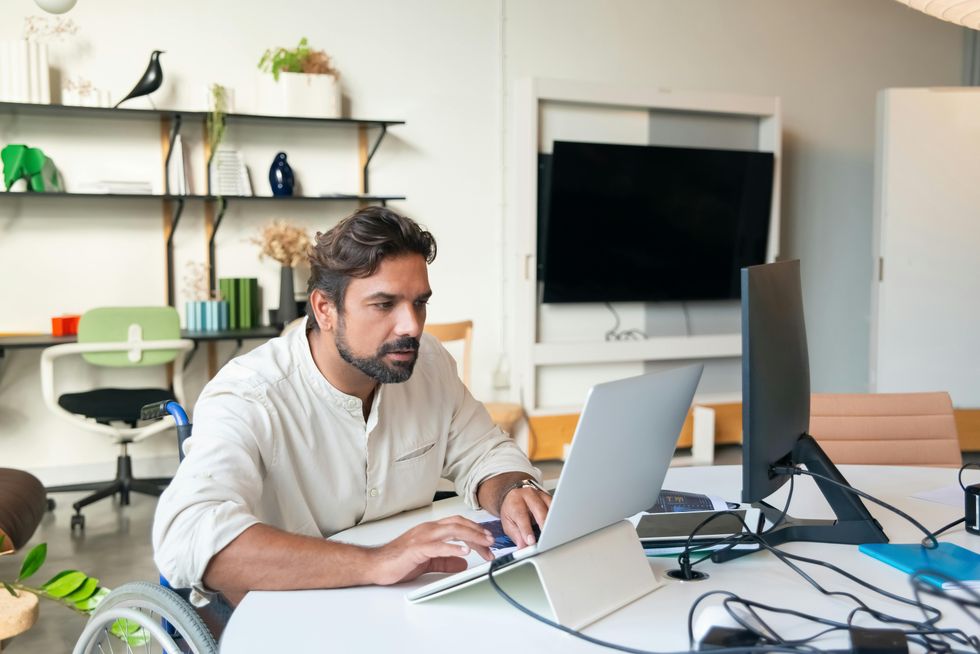 A man doing work at a computer in an office.