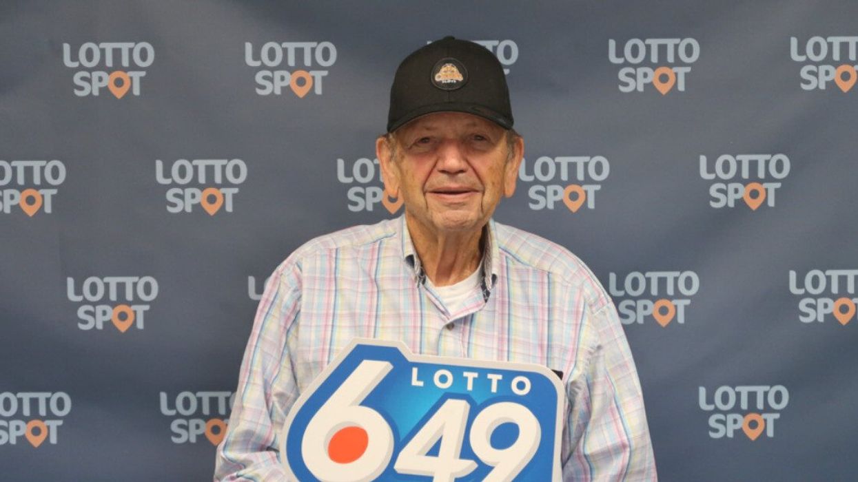 A man holding a Lotto 6/49 sign.