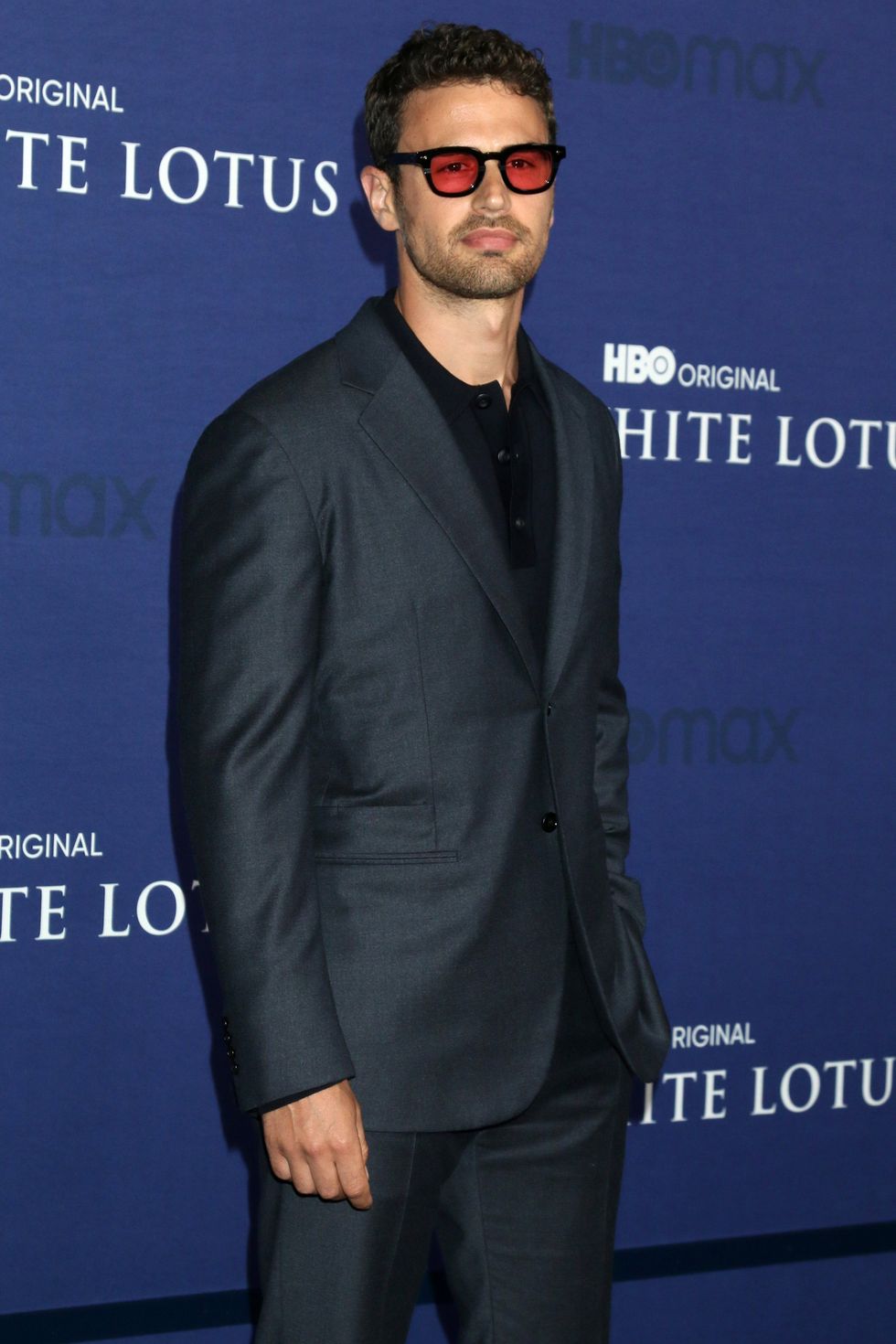A man in a suit and sunglasses posing for a photo.