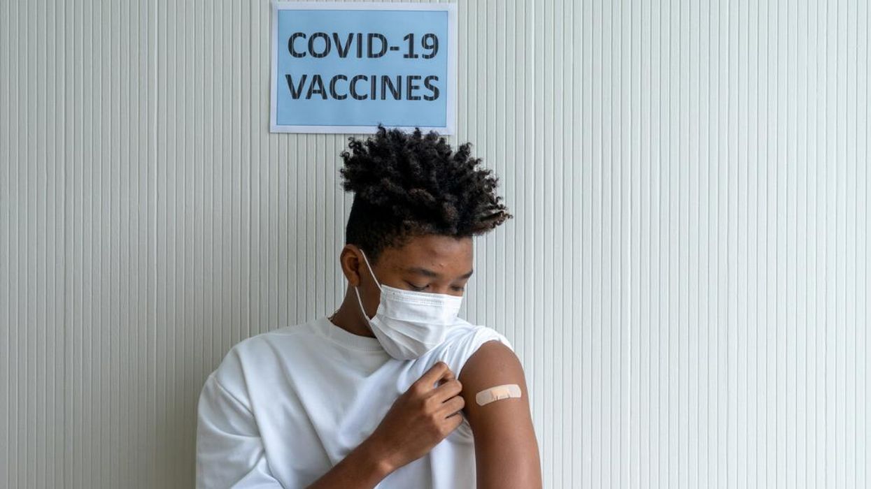 A man looks at his bandaid after receiving a COVID-19 vaccine.