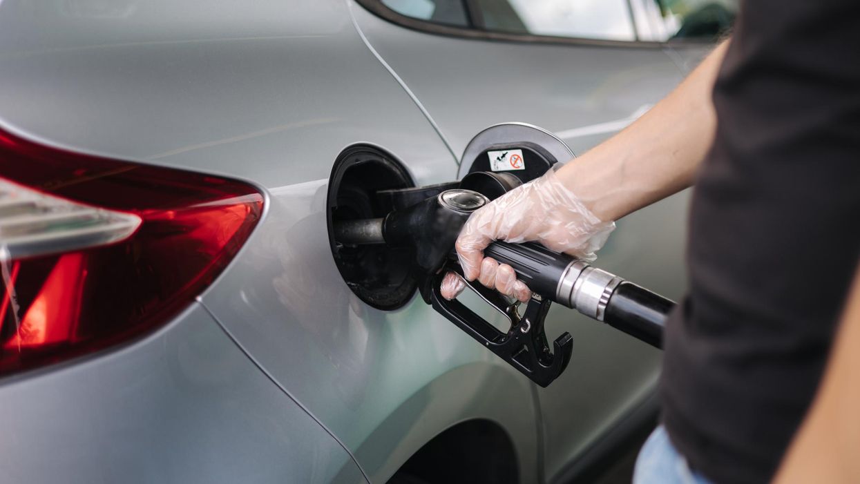 A man refuels a vehicle at a gas station.