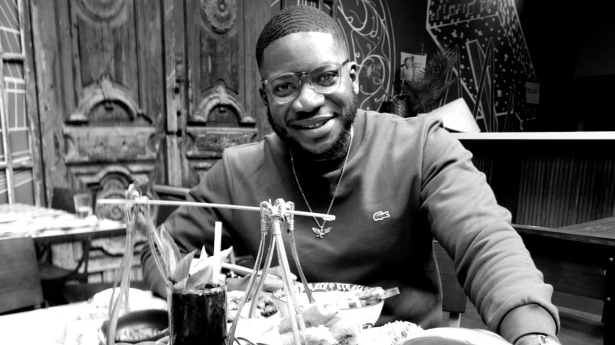 A man sitting in front of a table of food.