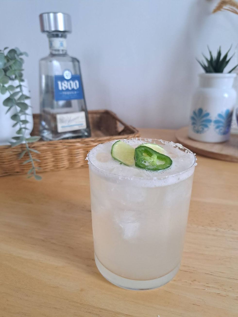 A margarita in a rocks glass, rimmed with salt and garnished with jalape\u00f1o and lime.