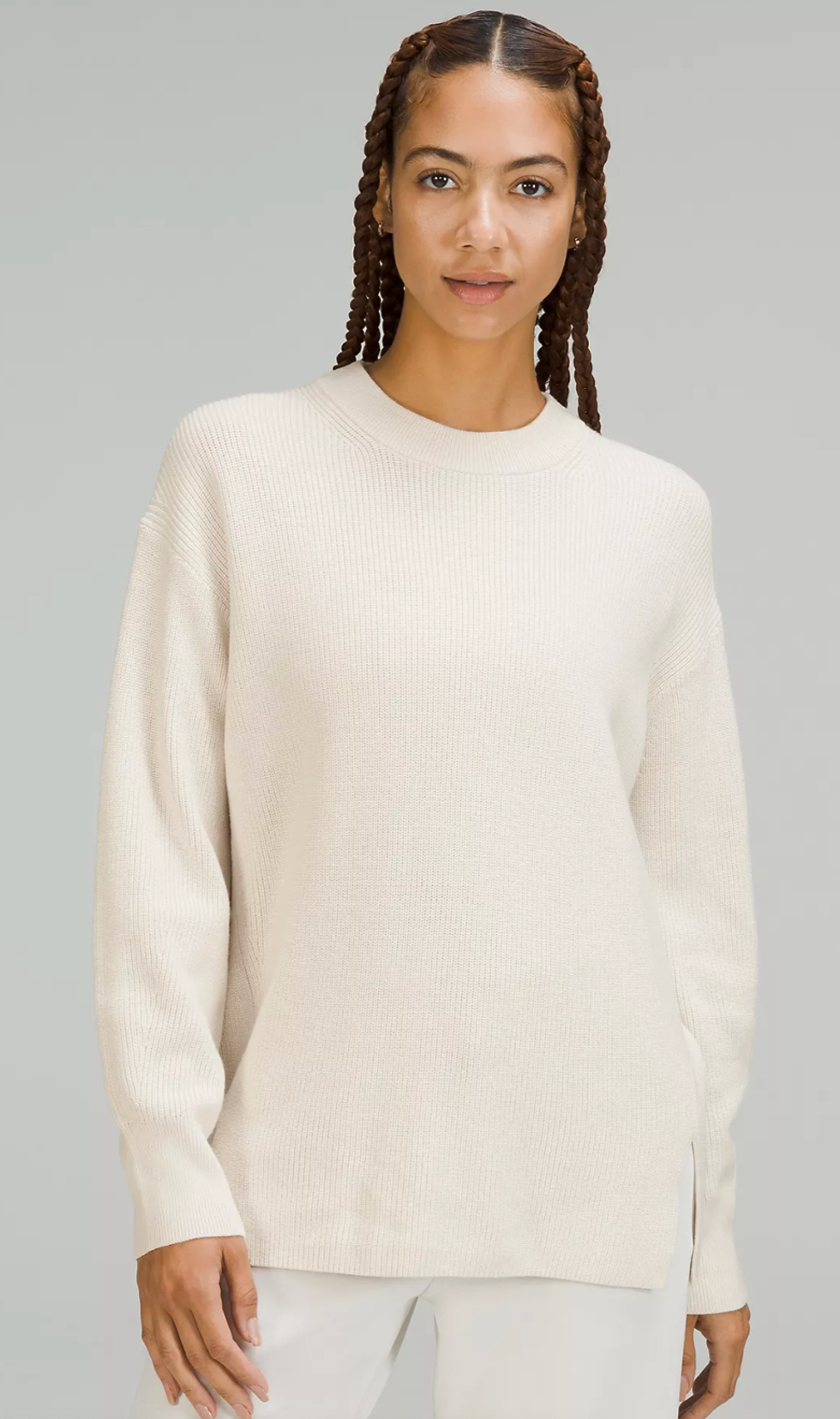 A model wearing the Merino Wool-Blend Ribbed Crewneck Sweater in white opal.