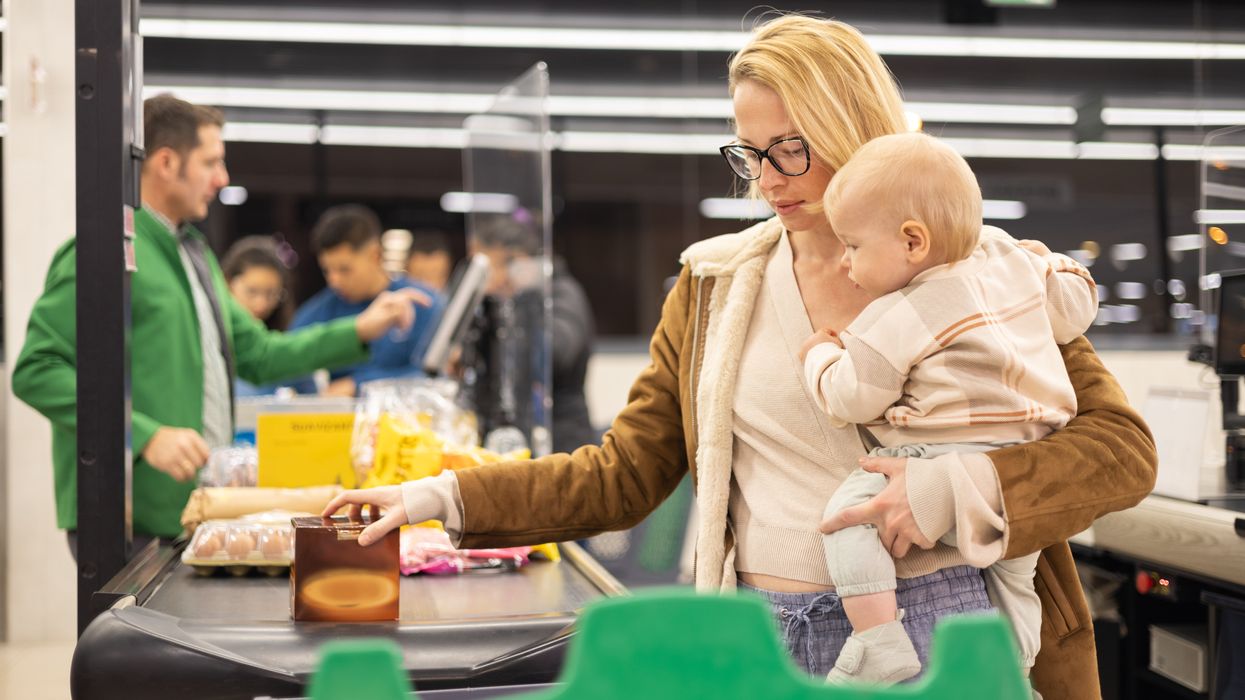 A mom with her child at the grocery checkout.