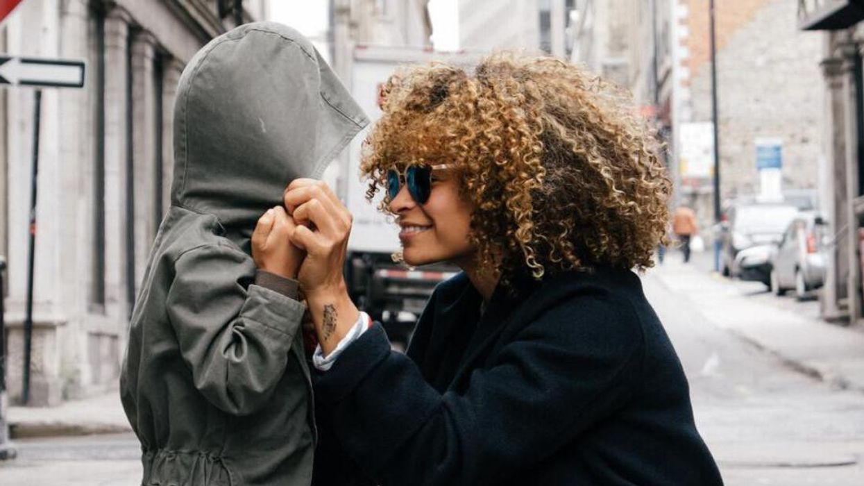 A mother covering her child's head.