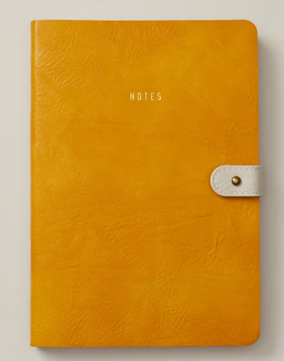 A mustard yellow notebook that says "notes" on the front.