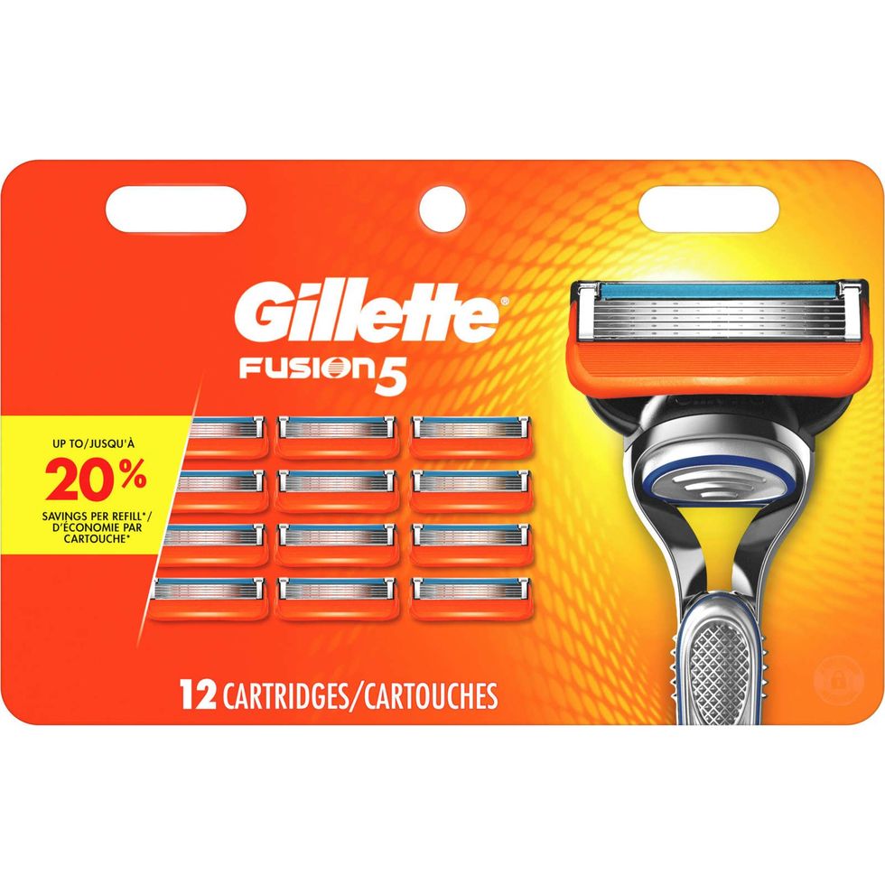 A orange and yellow box of 12 Gillette razor blade refills.