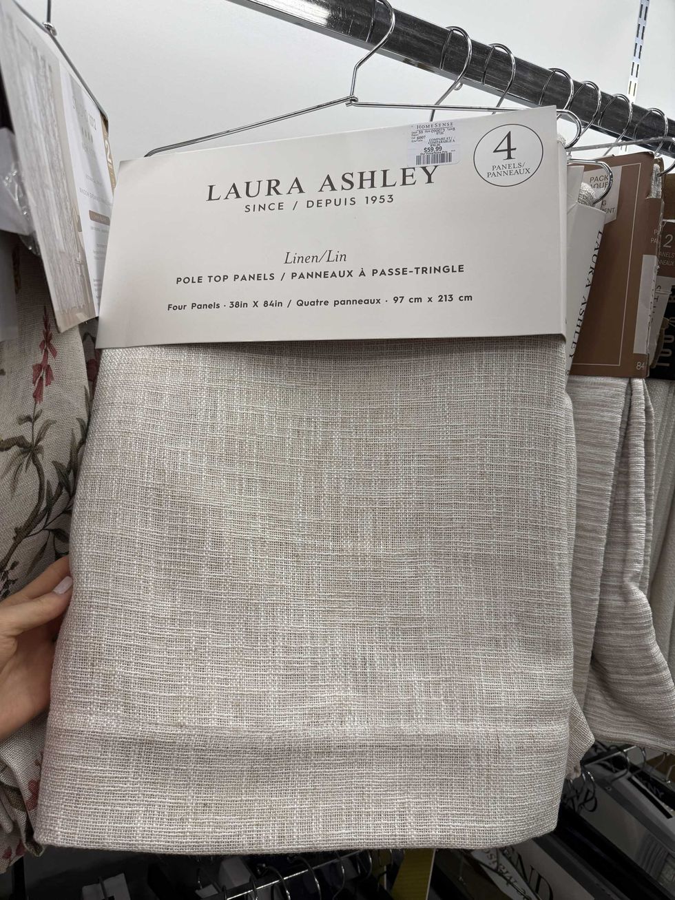 A pack of beige linen curtains hanging on a store shelf.