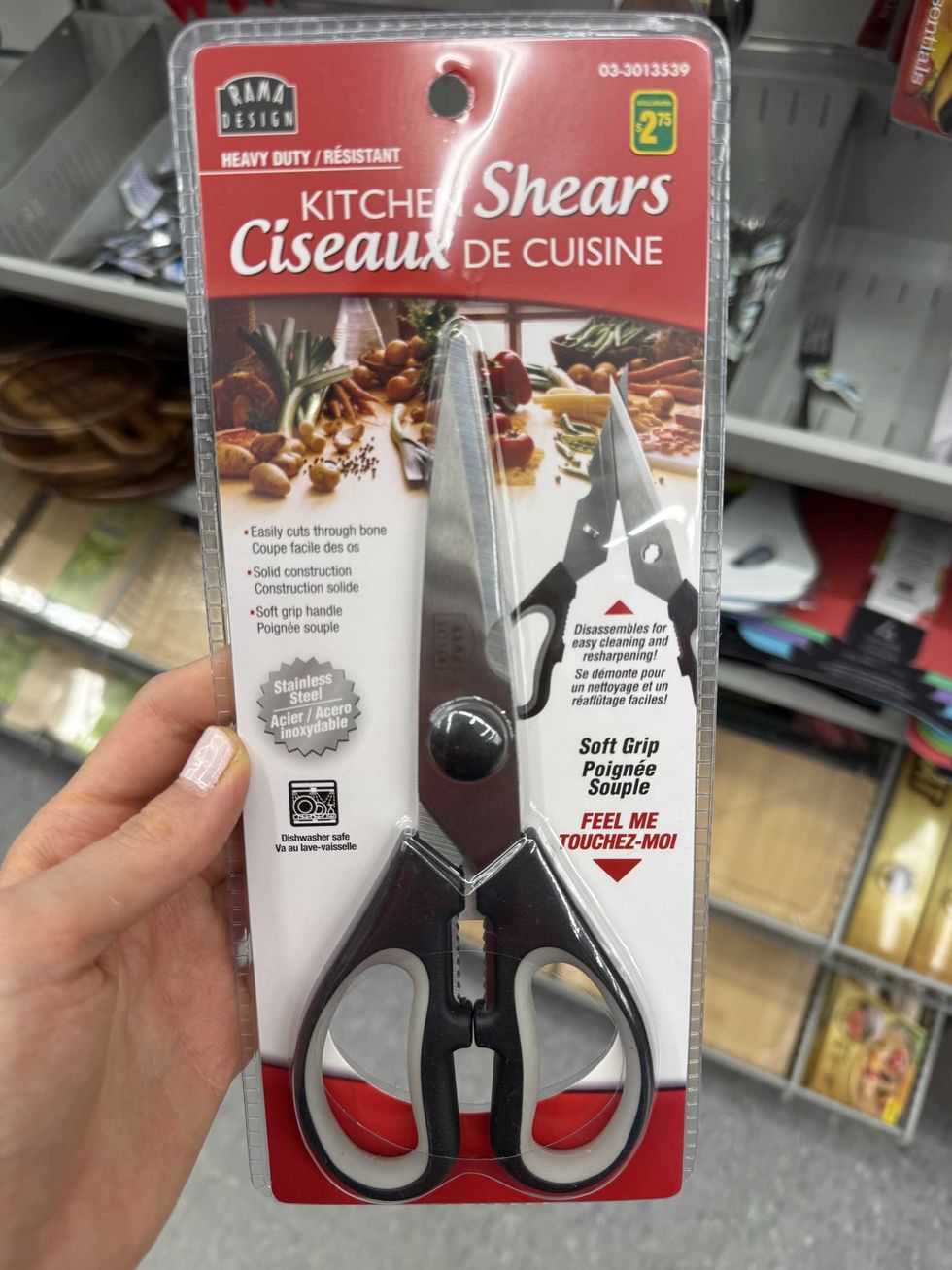 A pair of black and grey scissors and a label that reads kitchen shears.