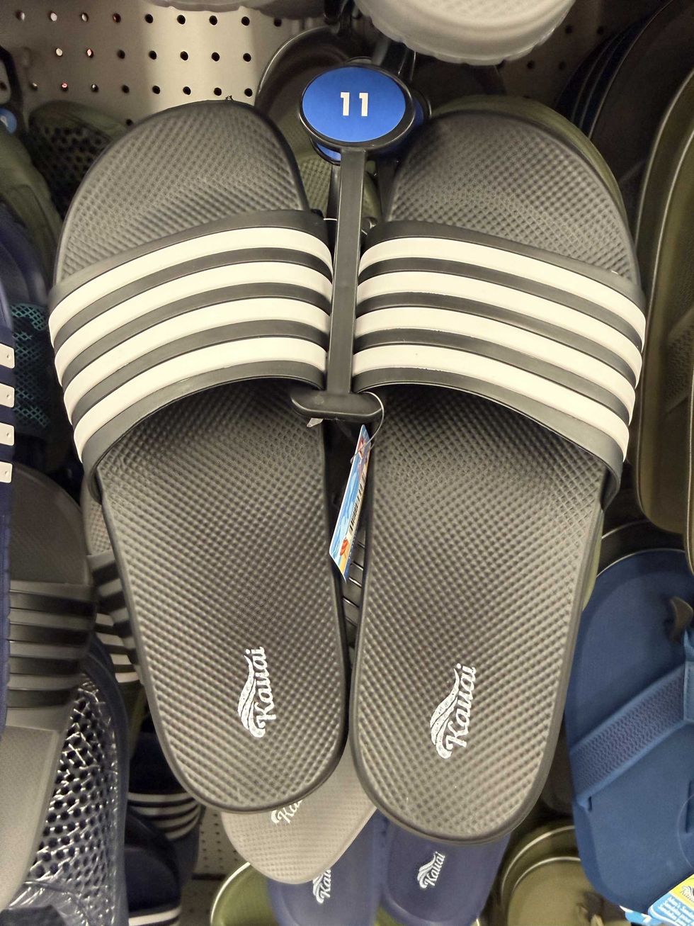 A pair of black and white slides on store shelf.
