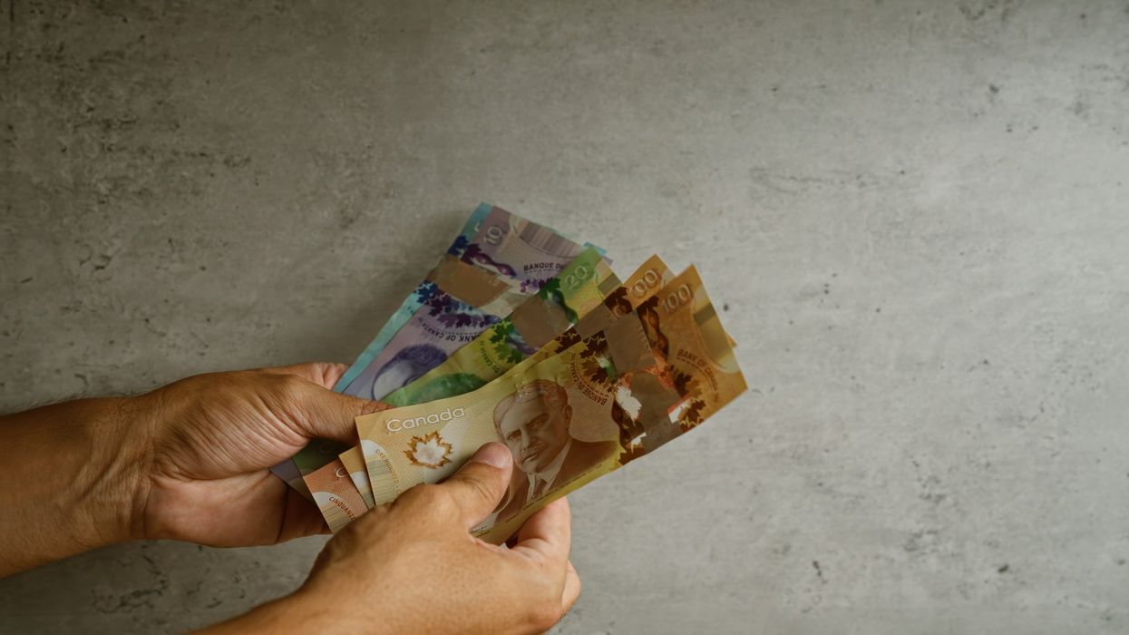 A pair of hands holding Canadian money (illustrative).